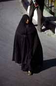 Traditional color of woman dress is black in Iran. Woman is dressed in black chador. Mashhad. Iran.