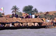 Life at Niger river. Large pinnase boat is carrying passangers and goods on the river. Mali.