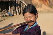 Woman from Dai Chin tribe playing at nose flute, Mindat village, Chin State. Myanmar (Burma).