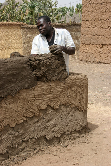 Building or reparing of muddy house. Rey Bouba village. Cameroon.