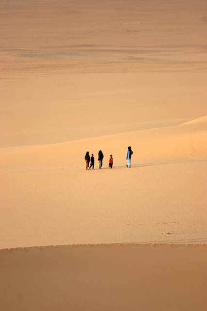 Arrakau - nomad family comes through sand dunes. Sahara desert. Niger.