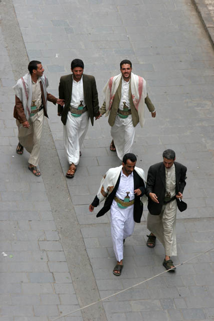 Men at traditional clothes at street at old quarter of Sana capitol. Every man is decorated by traditional dagger jambiya. Yemen.