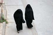 Women at traditional black clothes at street at old quarter of Sana capitol. Yemen.