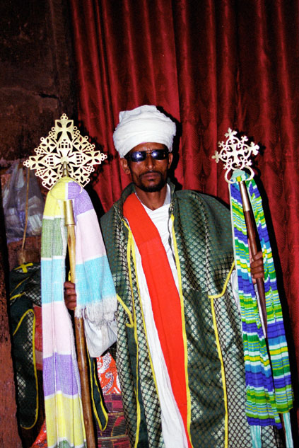 Stone church at Lalibela. Priest shows holy crosses. North,  Ethiopia.