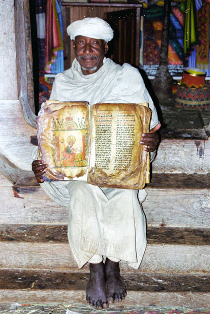 Priest shows old Bible made from goat skin. North,  Ethiopia.