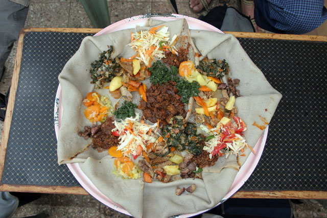 Traditional and common food - injara. Sour pankake served with variety of meet and vegertable. South,  Ethiopia.